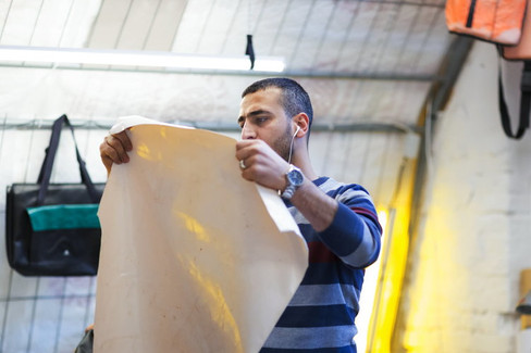 Khaldoun the tailer working with the material for a bag